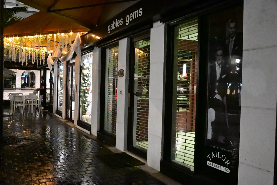 A sheltered walkway beside illuminated shop windows